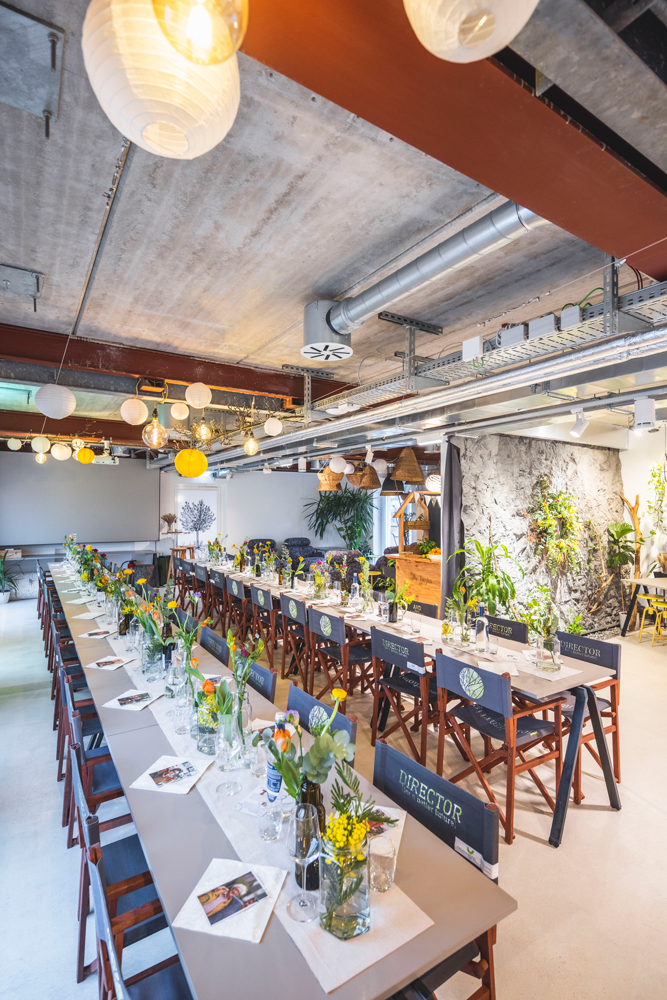 Blick in das Loft mit zwei langen, gedeckten Tafeln