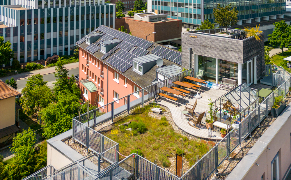 Draufsicht auf die Dachterrasse mit Glashaus, Sitzgelegenheiten und Dachgarten